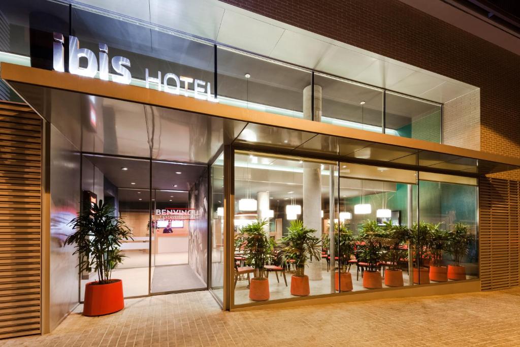 a store front of a mall with potted plants at Ibis Barcelona Centro (Sagrada Familia) in Barcelona