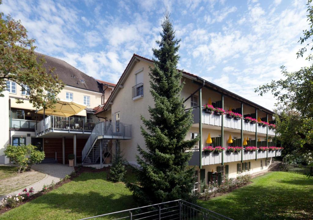 ein großes Gebäude mit einem Baum davor in der Unterkunft Hotel Alter Weißbräu in Bad Birnbach