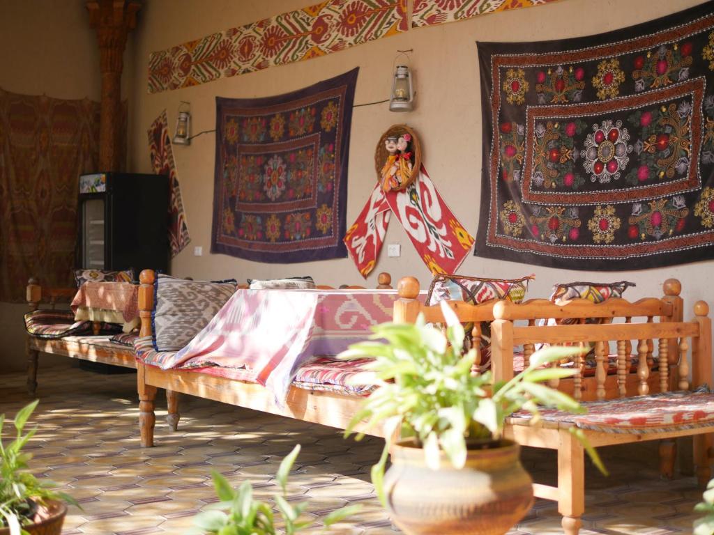 - un salon avec un canapé et des tapisseries murales dans l'établissement Guest House Ikathouse, à Margilan