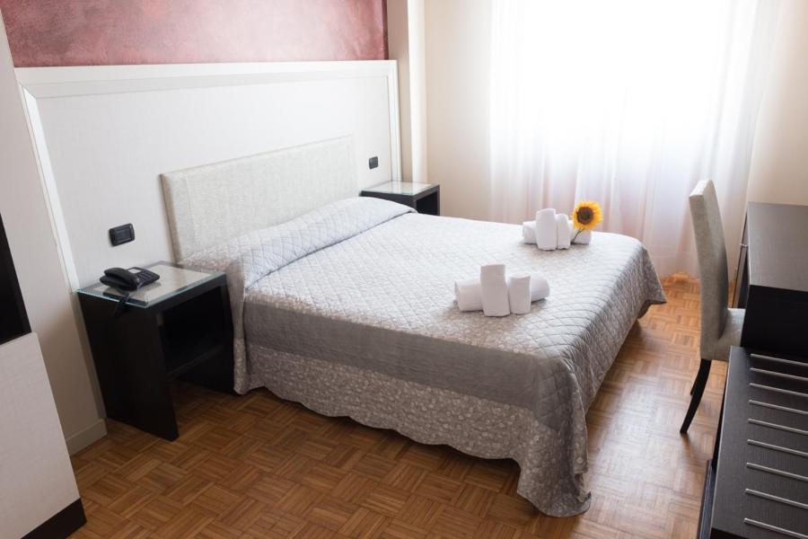 a bedroom with a bed with two candles on it at Hotel Astoria in Fidenza