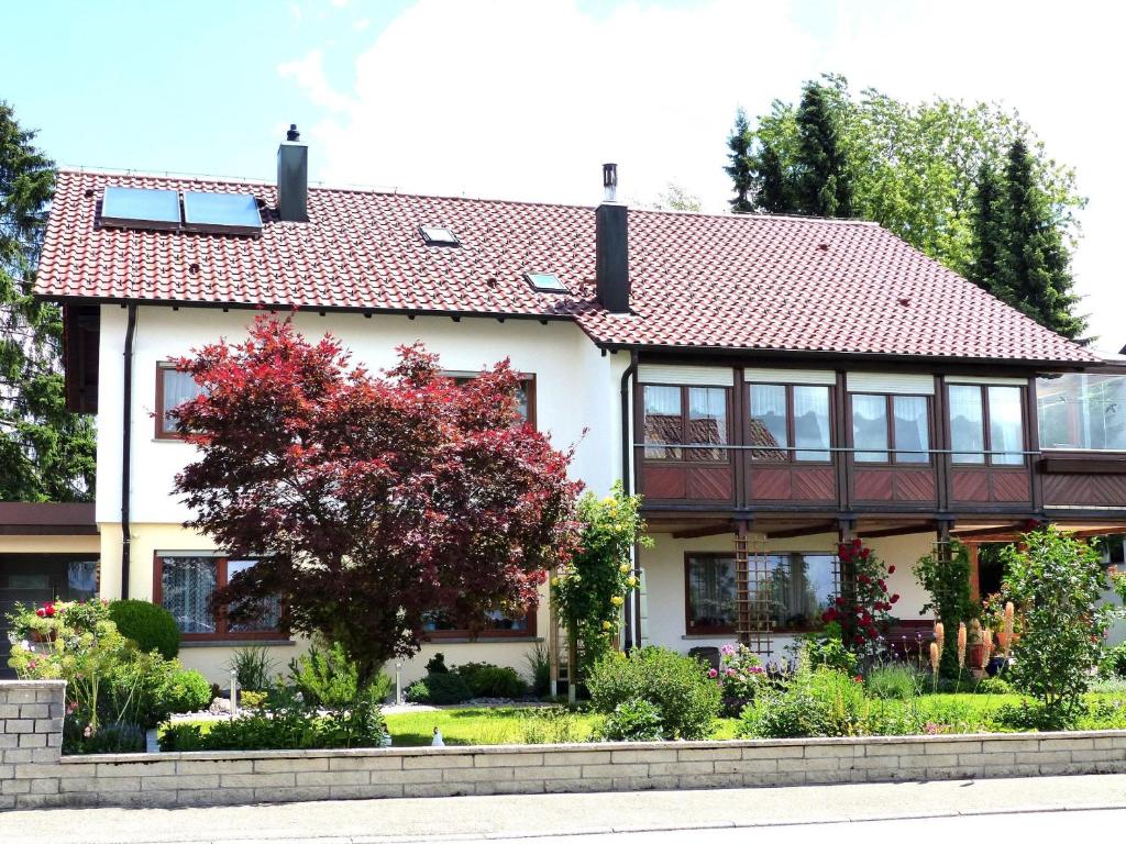 een wit huis met een rood dak bij Ferienwohnung Janko in Meßstetten