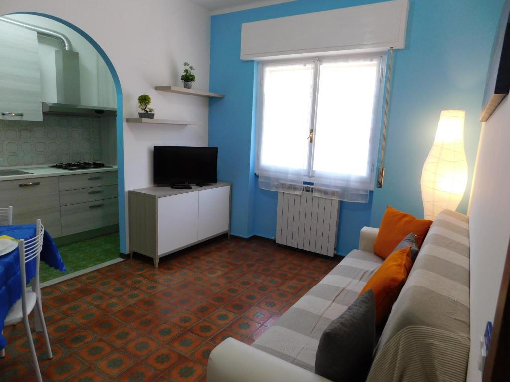 een woonkamer met een bank en een raam bij Casa Azzurra in Riva Ligure