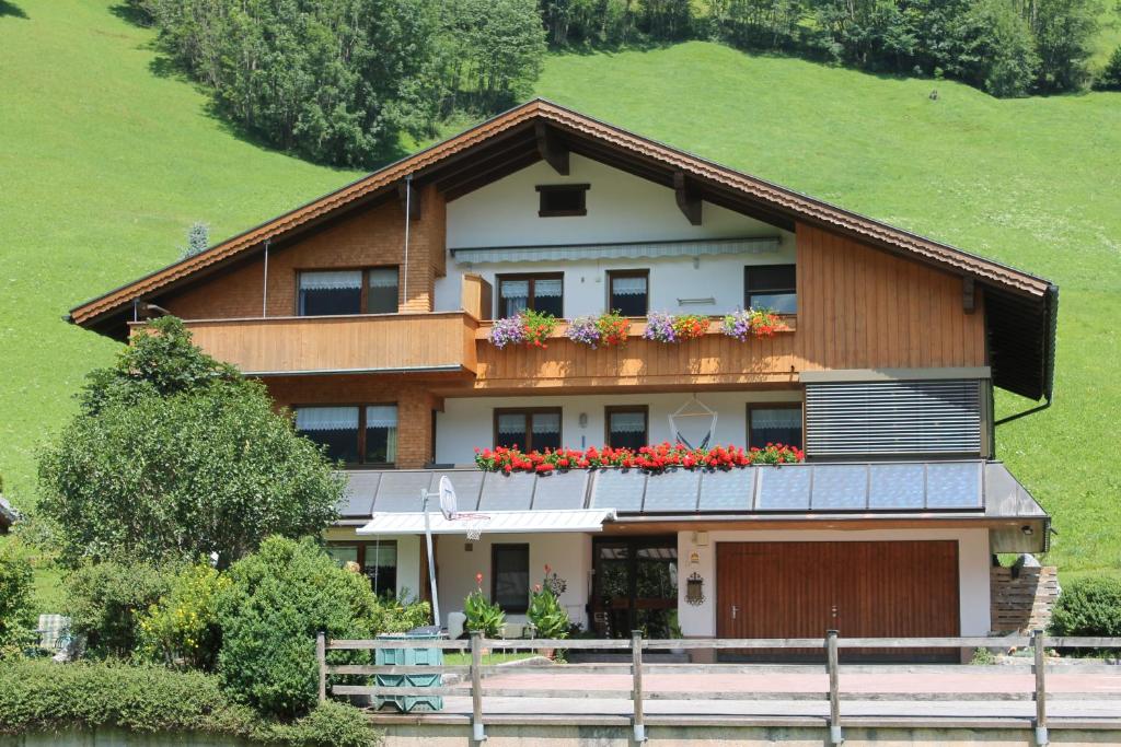 a house on a hill with flowers on the balcony at Rüf Wohlfühl-Apartments in Au im Bregenzerwald
