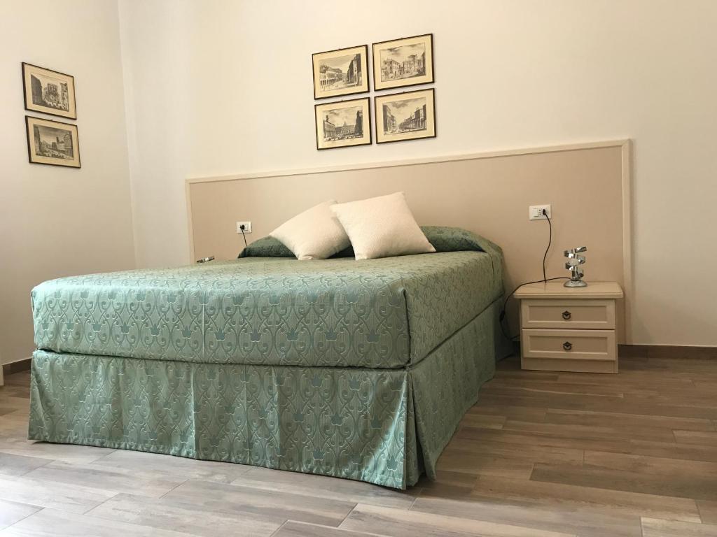 ボローニャにあるGuest House in Piazzaのベッドルーム1室(ベッド1台、緑の掛け布団付)