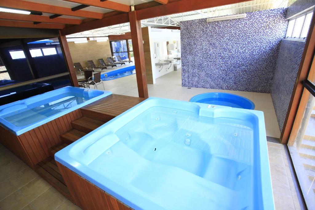 a bathroom with a blue tub and blue flooring at Sky Ville Hotel Gramado in Gramado