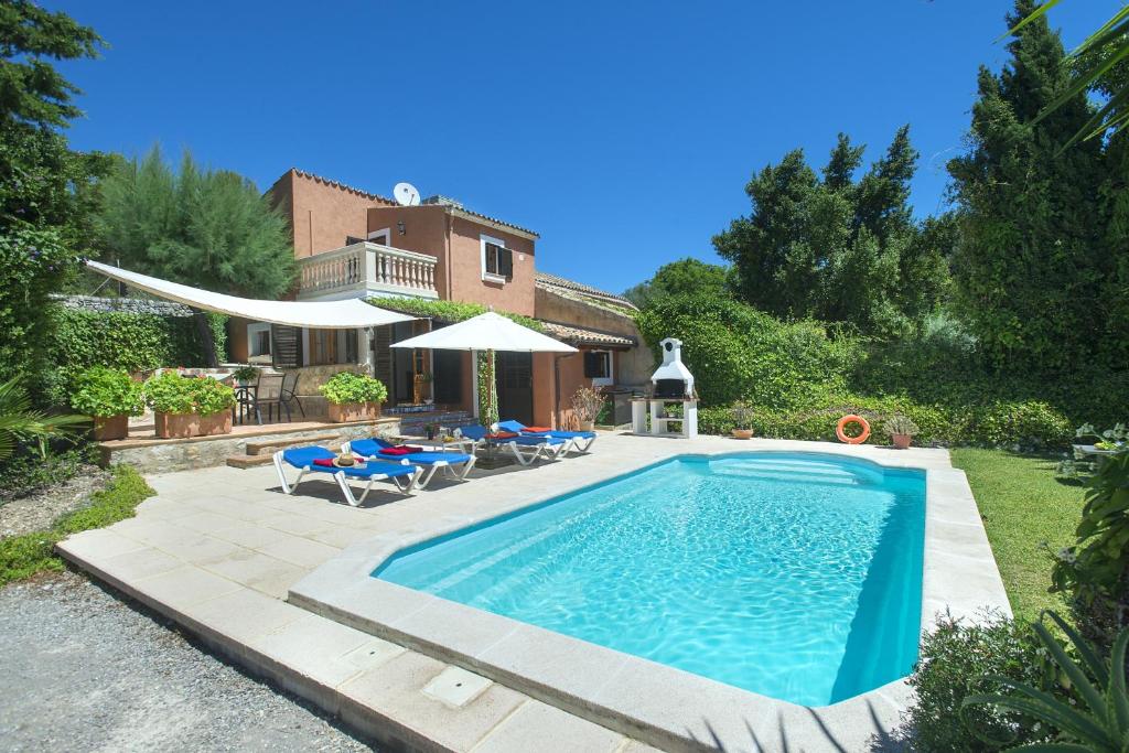 a swimming pool in front of a house at Owl Booking Villa Bennasar - Rustic Stay in Pollença
