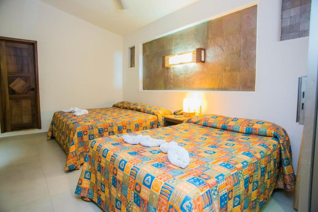 - 2 lits dans une chambre d'hôtel avec des serviettes dans l'établissement Hotel y Villas Quinta Minas, à Los Ayala