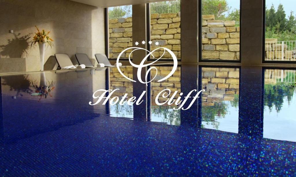 una hall con piscina e un cartello regalo dell'hotel di Hotel Cliff Belvedere a Izola