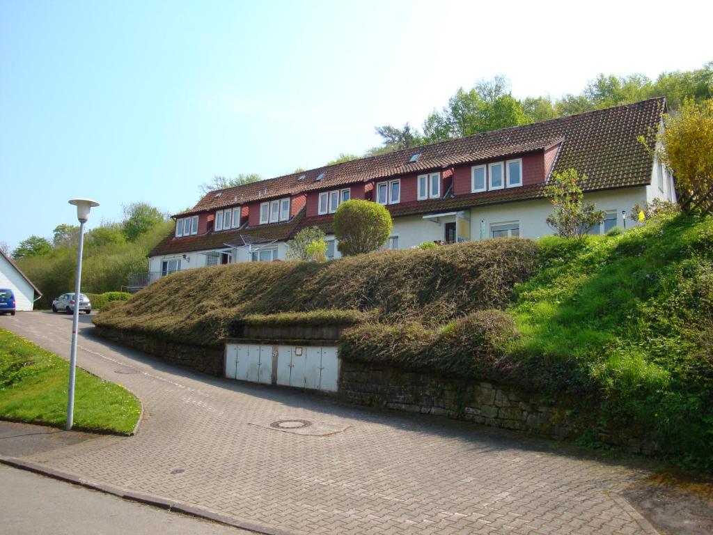 a house with a grassy hill next to a street at Ferienwohnung Mebes in Polle
