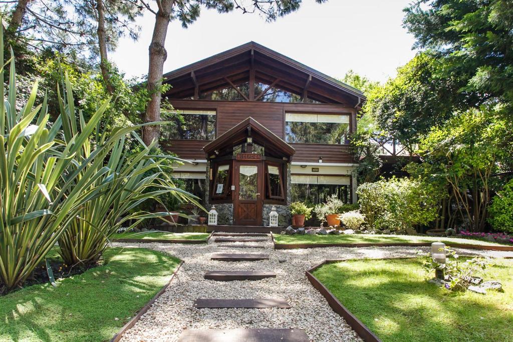 una casa con un camino que conduce a la puerta principal en Cabañas La Mandrágora en Mar de las Pampas