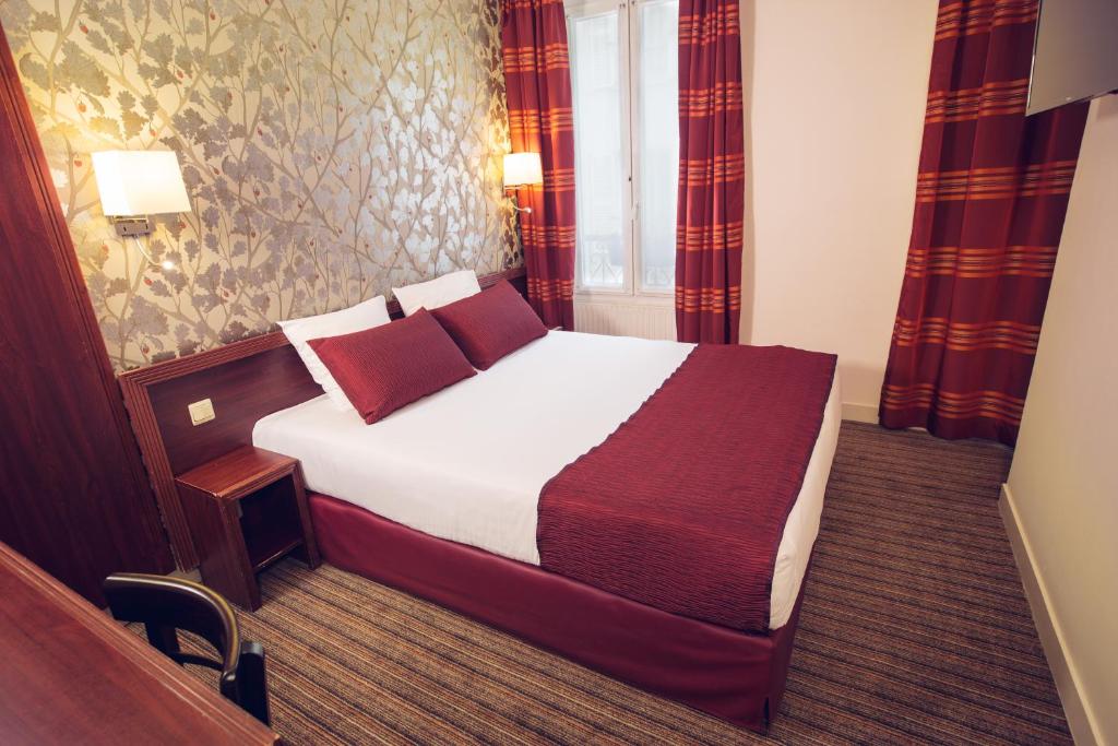 Cette chambre comprend un lit avec des oreillers rouges. dans l'établissement Timhotel Paris Gare de Lyon, à Paris