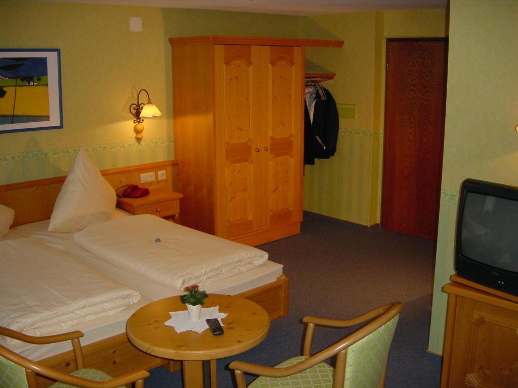 a room with a bed and a table and a tv at Landgasthof Schuck in Idar-Oberstein