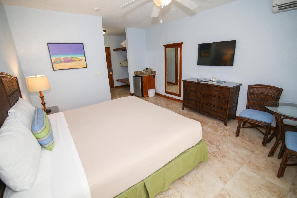 a bedroom with a bed and a table and a television at Coco La Palm in Negril