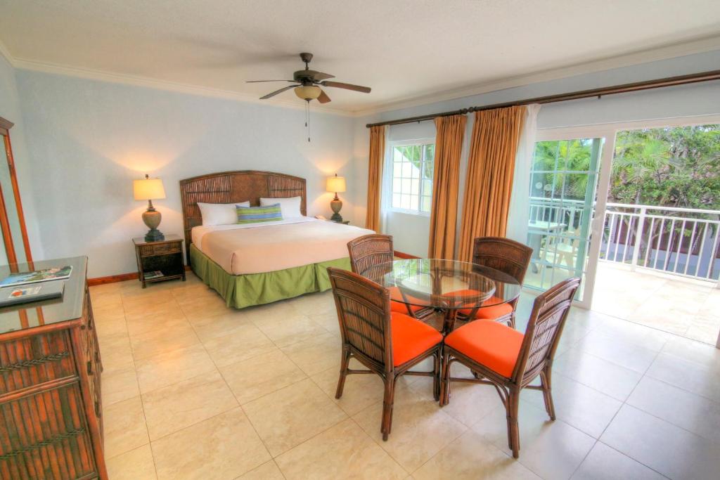 a bedroom with a bed and a glass table and chairs at Coco La Palm in Negril