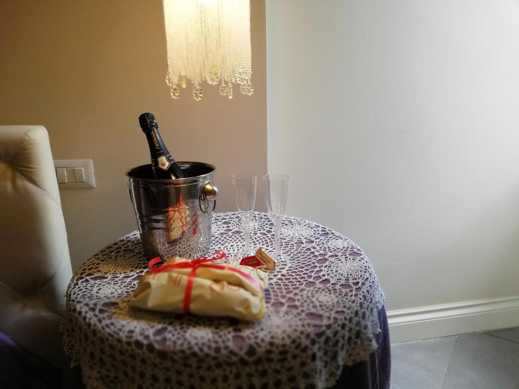 ナポリにあるAnema e Core Apartmentのワイン1本とケーキをテーブルに用意しています。