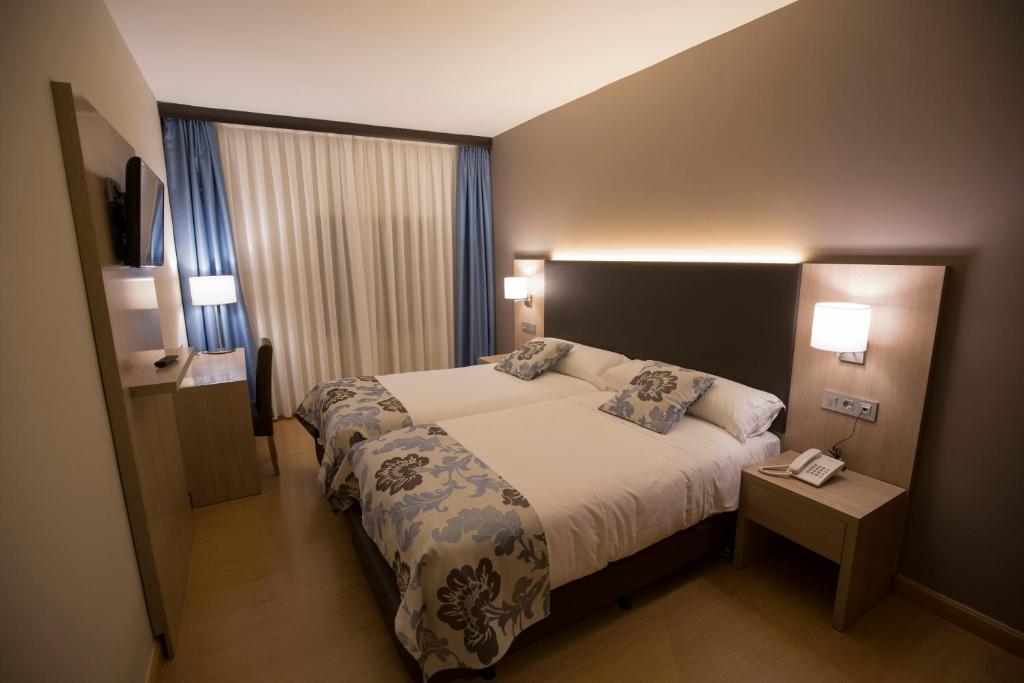 a hotel room with a bed and two pillows at Hotel Valentin in Aguilar de Campóo