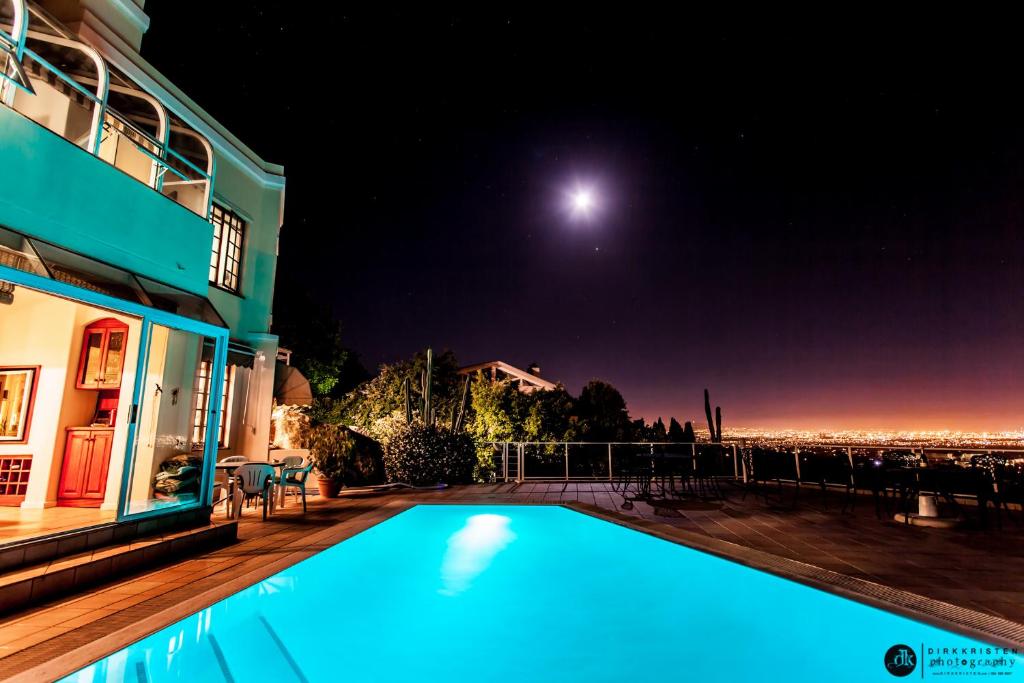 a swimming pool in front of a house at night at Panorama Guest House in Cape Town