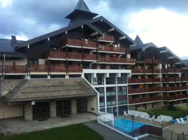 ル・プラ・ド・リにあるTerrasses Du Mont Blancの大きな建物の正面にプールがあります。
