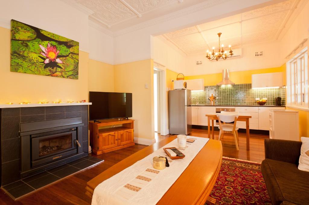 a living room with a fireplace and a kitchen at Taree Apartment in Taree