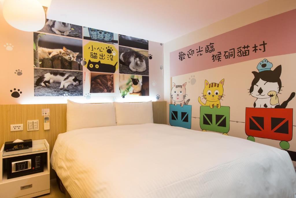台北的住宿－清翼居采風館，卧室配有一张床,墙上挂有图片