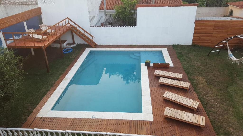 a swimming pool in a yard with a wooden deck at La Rosarita Club in Santa Teresita