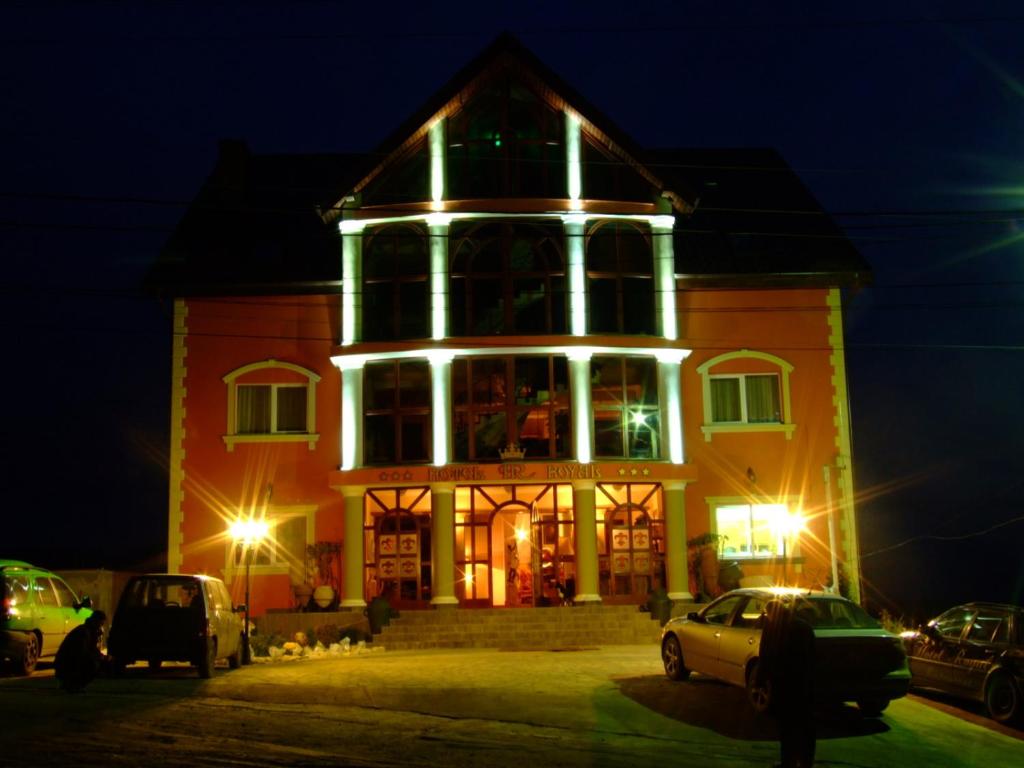 un gran edificio con luces encendidas por la noche en Hotel Royal, en Zalău