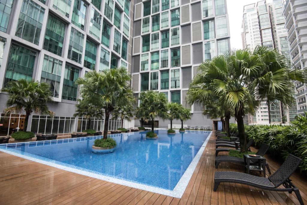 una piscina en medio de un edificio con palmeras en Soho Suites @ KLCC by Luxury Suites Asia, en Kuala Lumpur