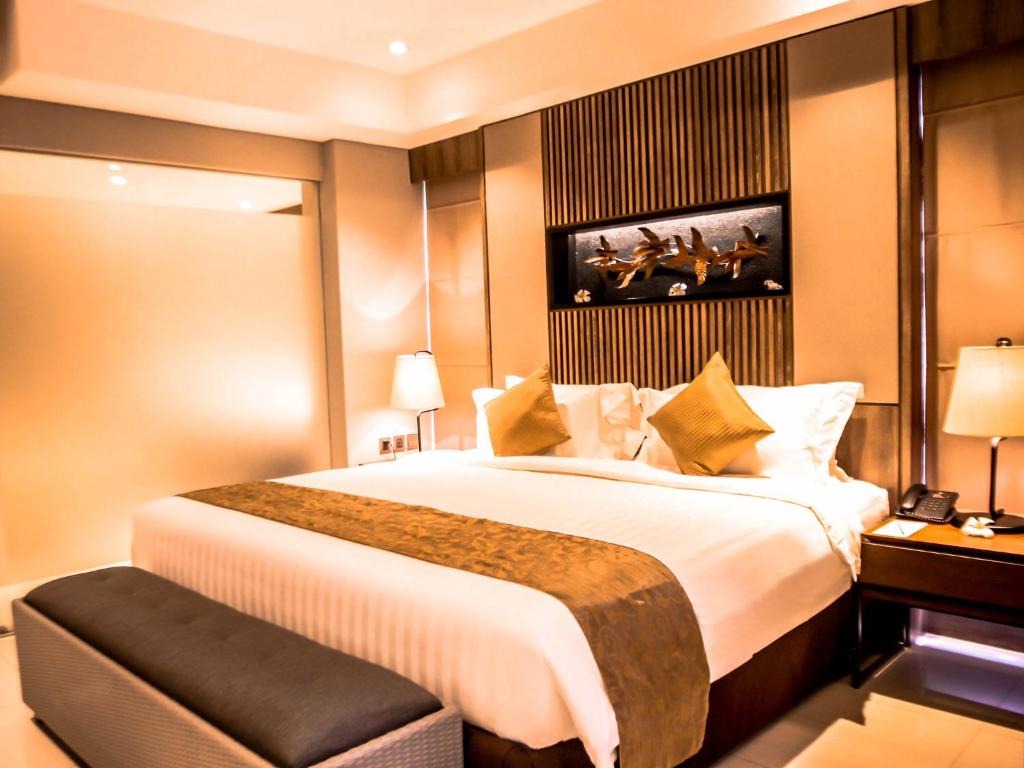 A bed or beds in a room at The Nest Hotel Nusa Dua
