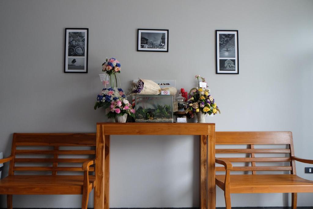 a dining room table with two chairs and flowers on it at The Besavana Phuket - SHA Extra Plus in Phuket Town