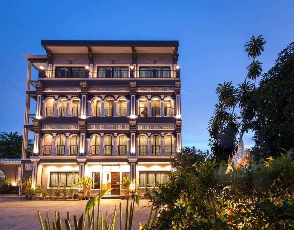 a large building with lights on it at night at The Besavana Phuket - SHA Extra Plus in Phuket Town