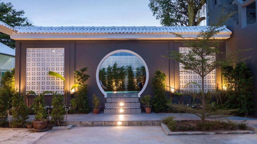 a courtyard with an arched window with plants and lights at The Besavana Phuket - SHA Extra Plus in Phuket Town