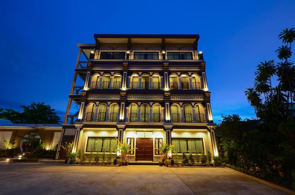 a large building with lights on it at night at The Besavana Phuket - SHA Extra Plus in Phuket Town