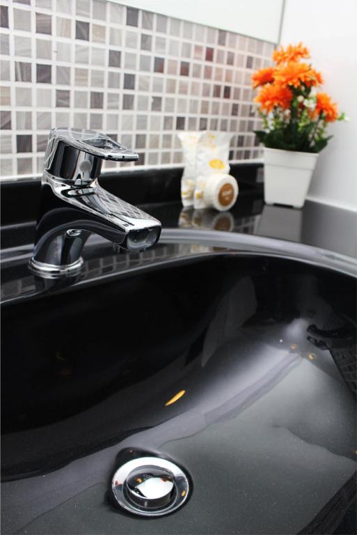 a black sink with a faucet on top of it at Simplitel in Karon Beach