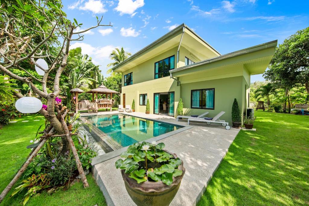 a house with a swimming pool in a yard at Baan Suaan Serenity in Laem Sor