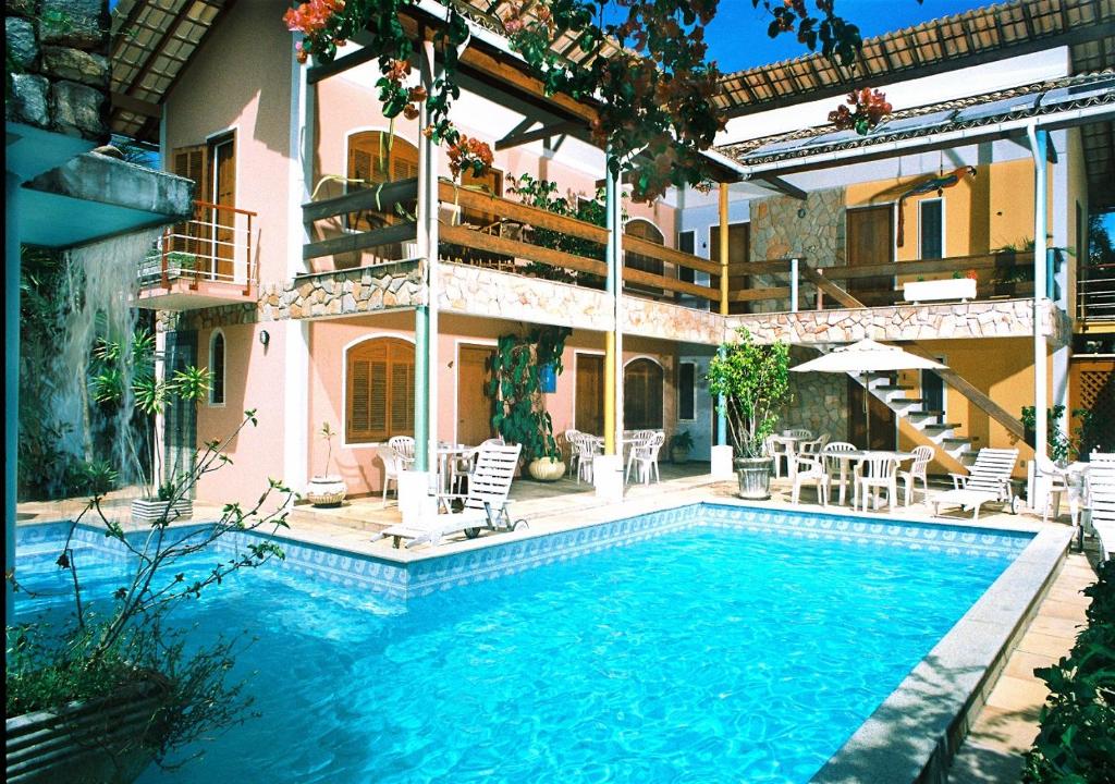 una piscina di fronte a una casa di Pousada Vitória a Ilhéus