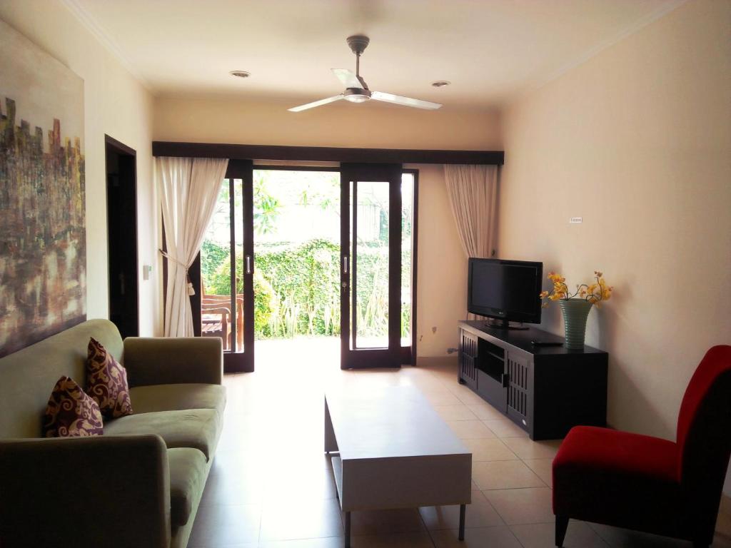 a living room with a couch and a tv at Bali Paradise Apartments in Sanur