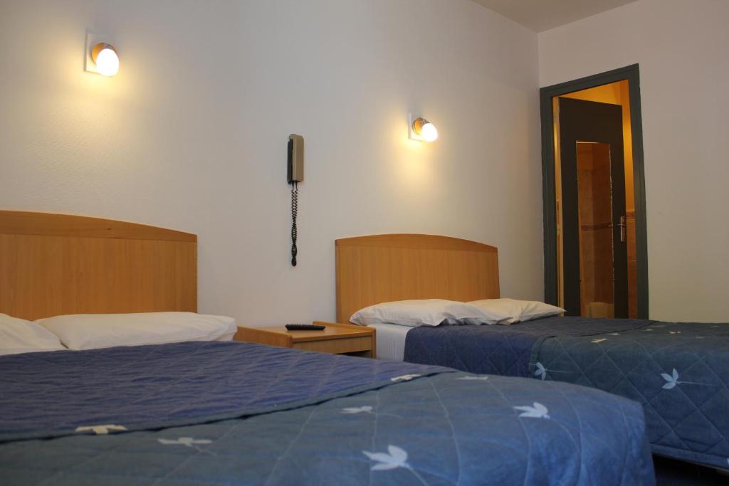 Postel nebo postele na pokoji v ubytování Hotel Le Chapitre