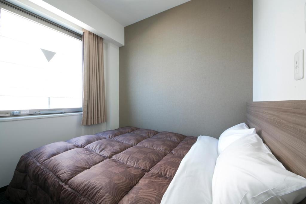 Postel nebo postele na pokoji v ubytování WASHINGTON R&B Hotel Shin Osaka Kitaguchi