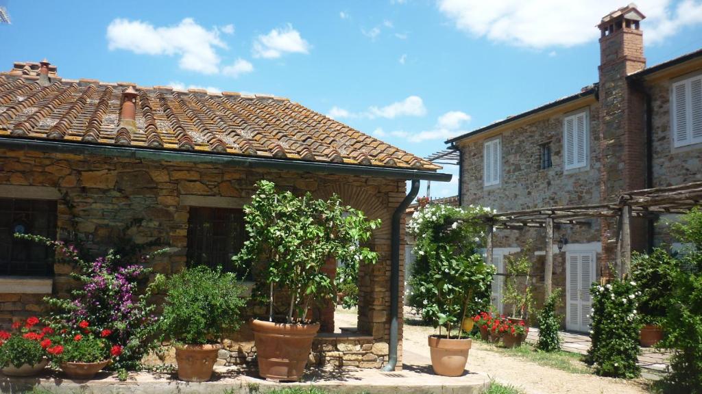una casa de piedra con macetas delante de ella en Agriturismo Baratti, en Baratti