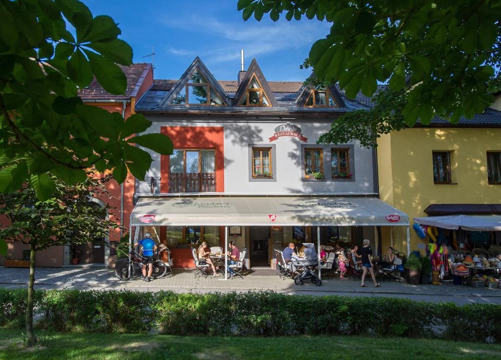 a group of people sitting outside of a building at Penzion Pohoda in Frymburk