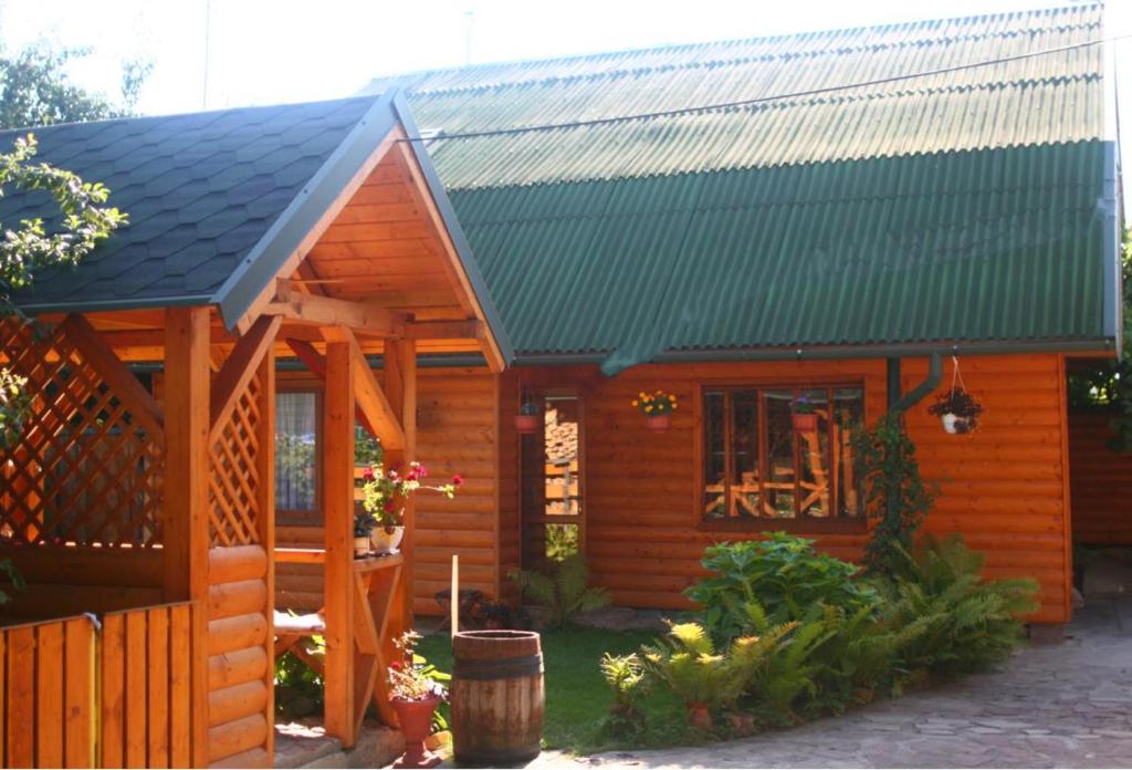 a small wooden cabin with a green roof at Friendly House in Kolomiya