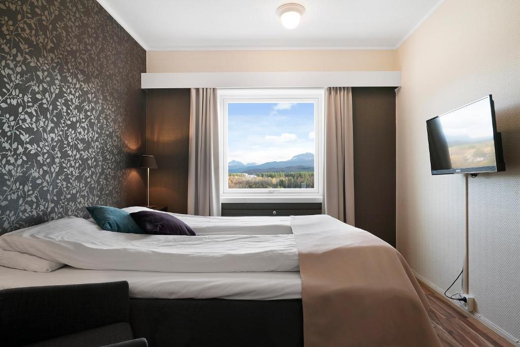 a bedroom with a large bed and a window at Bardufoss Hotell in Bardufoss