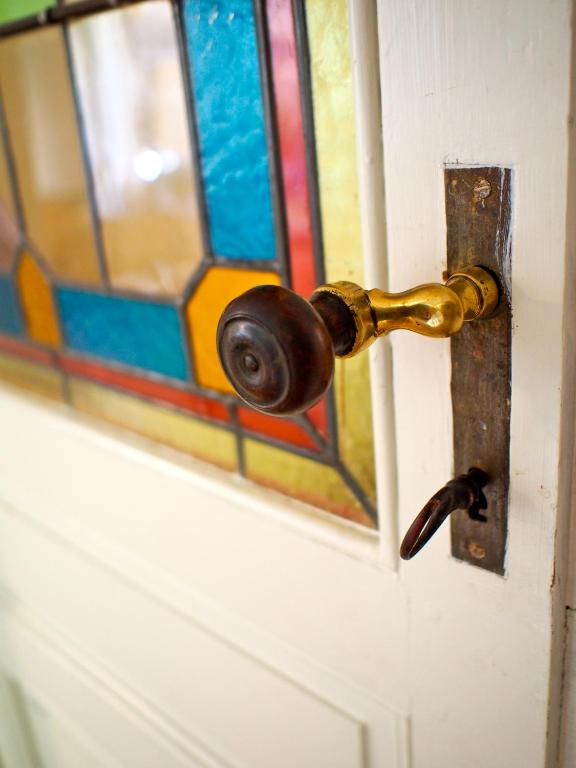 une porte avec un bouton de porte et un vitrail dans l'établissement Les Chambres d'Art, à Bordeaux