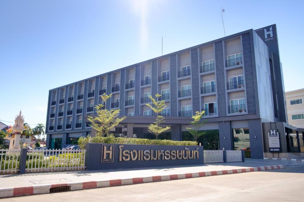 a building with a sign in front of it at Hansanan Hotel in Phitsanulok