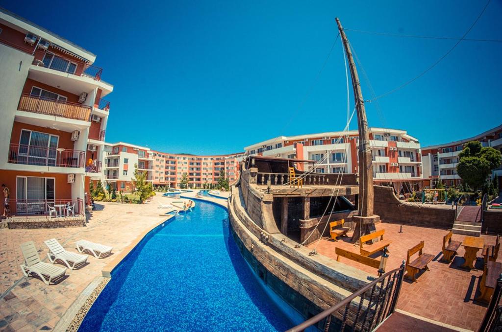 a boat in a pool next to some buildings at GT Privilege Fort Beach Apartments in Elenite