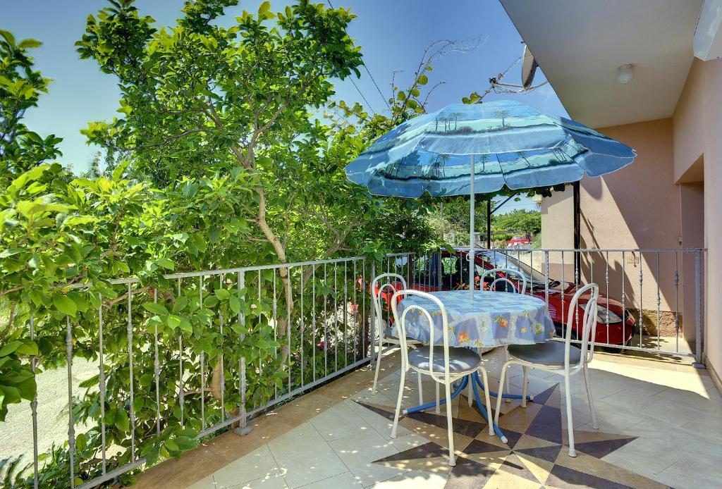 a table and chairs on a balcony with an umbrella at Apartments Danilo in Medulin