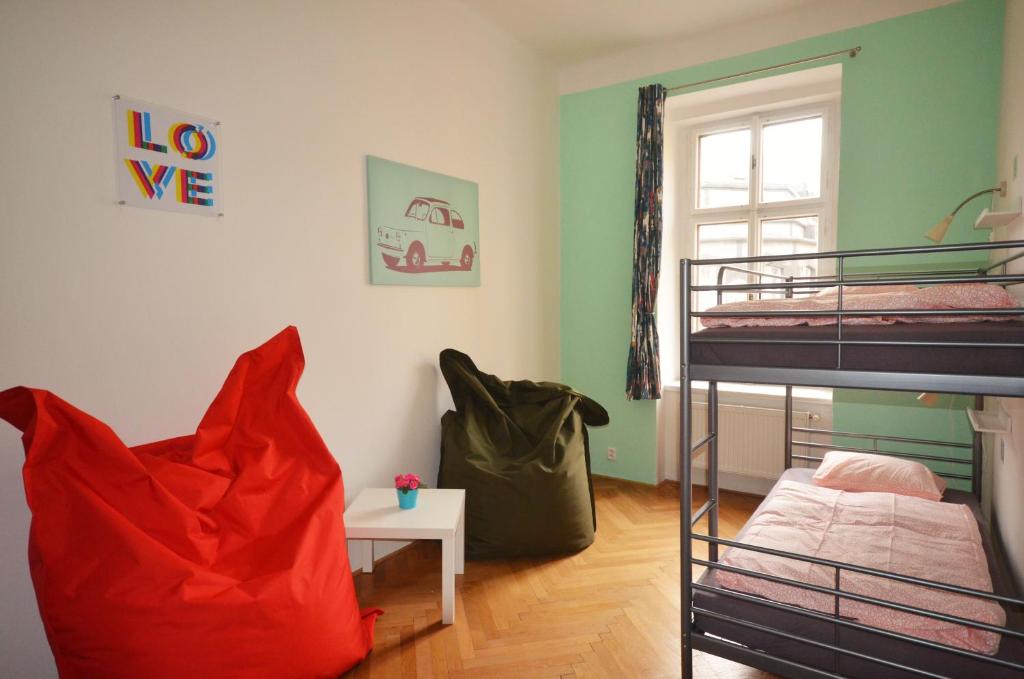 a room with a bed, a chair, and a tv at Travel&Joy backpackers in Prague