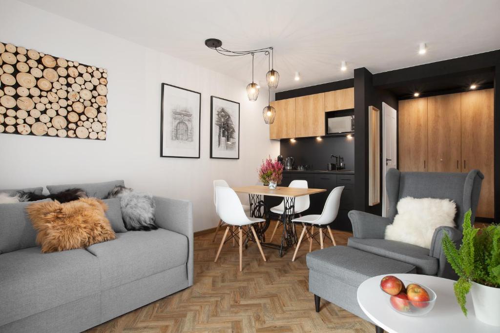 ein Wohnzimmer mit einem Sofa und einem Tisch in der Unterkunft Miód Malvina Apartamenty in Krynica-Zdrój