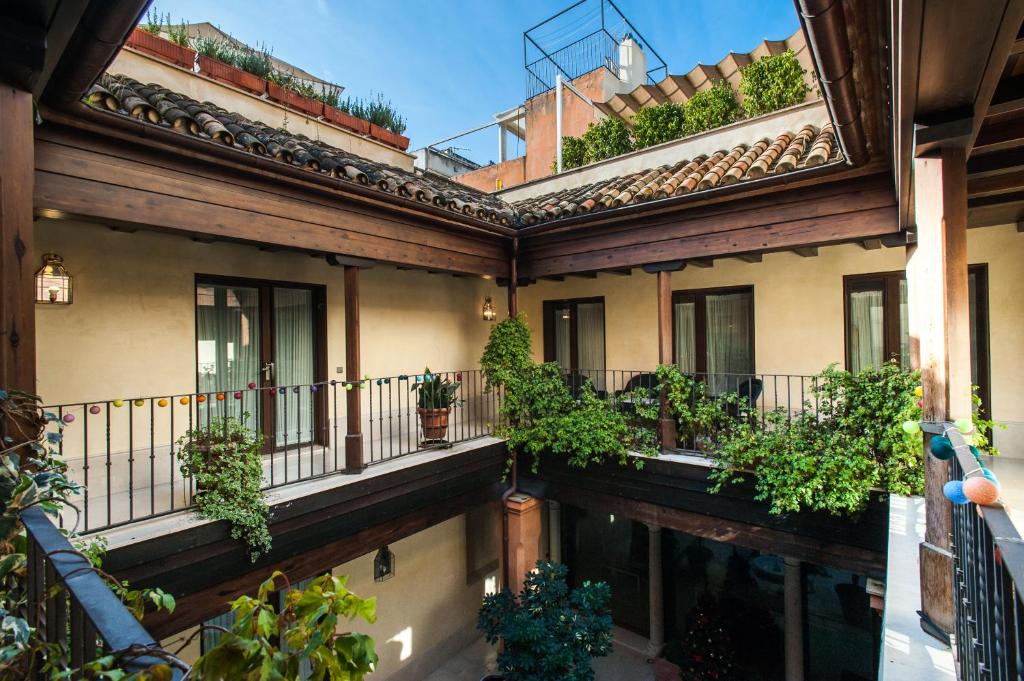a building with lots of windows and lots of plants at AT apartamentos & VTV Conde de Torrejón 10 in Seville