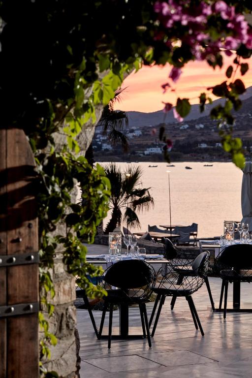 a table and chairs with a view of the beach at Poseidon of Paros Hotel & Spa in Chrissi Akti